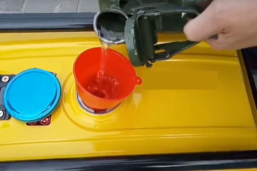 Der Treibstofftank eines Notstromaggregats ist offen und es wird mit einem Trichter aufgefüllt.